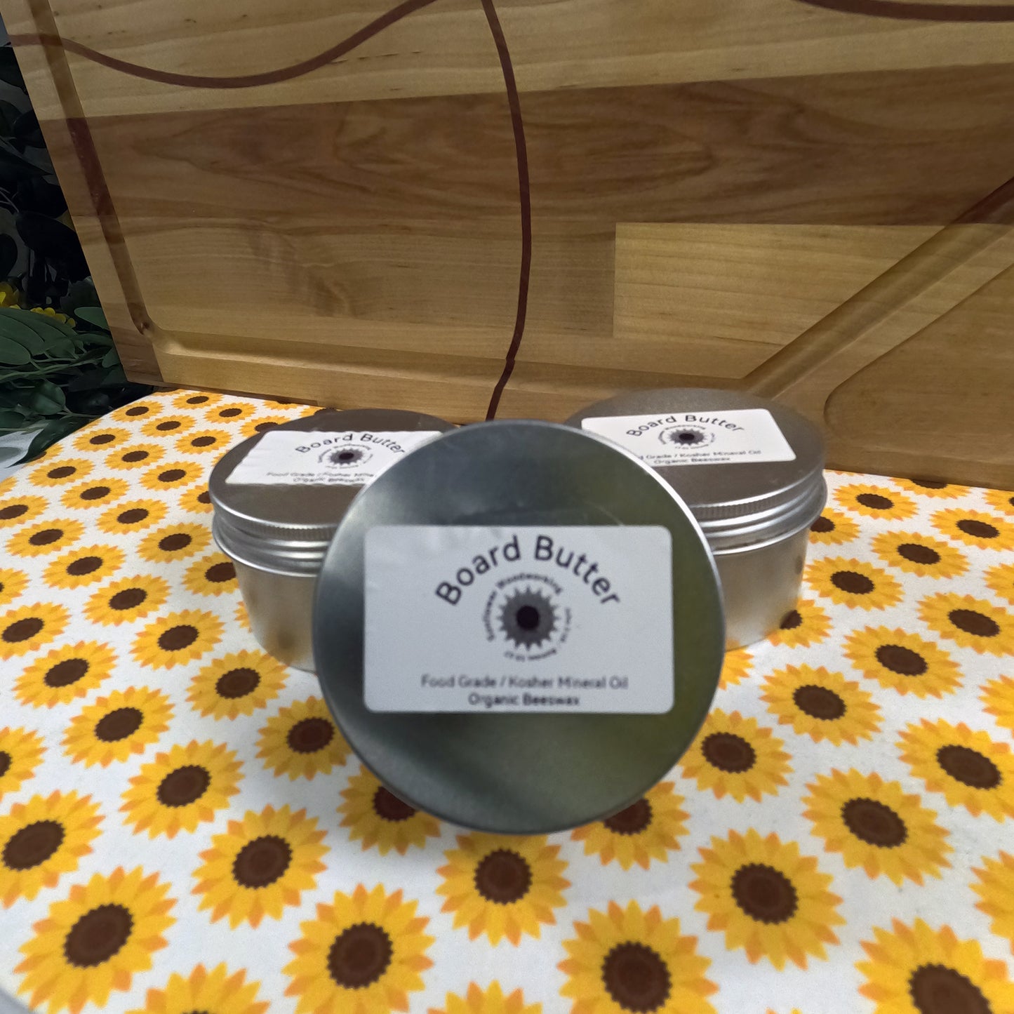 Board Butter tins on a sunflower-patterned tablecloth with a wooden background