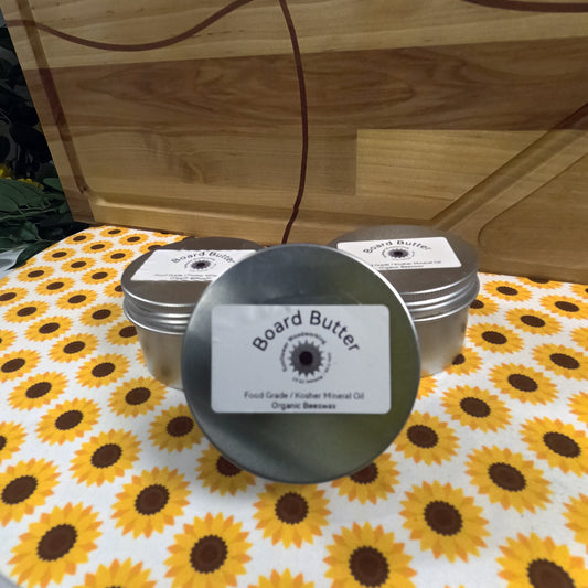 Board Butter tins on a sunflower-patterned tablecloth with a wooden background