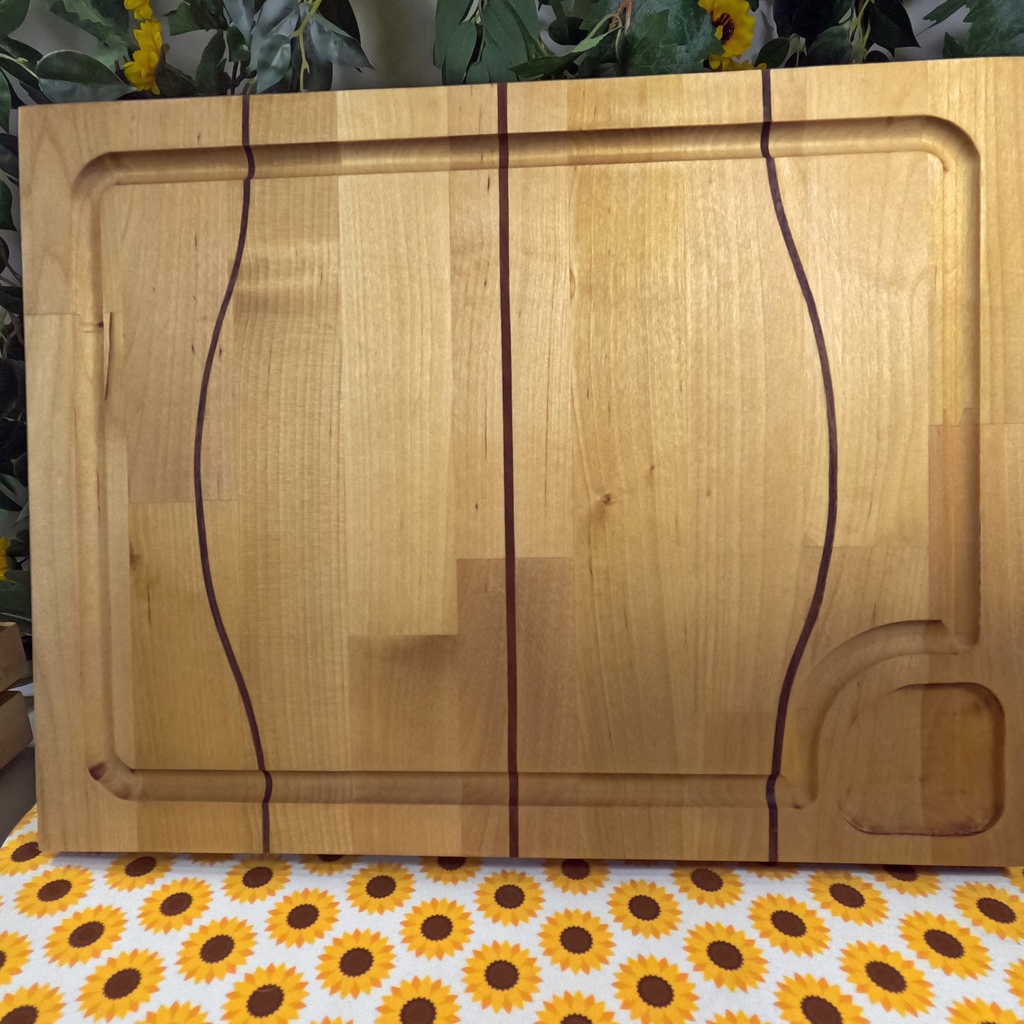 Wooden cutting board on a tablecloth with sunflower pattern