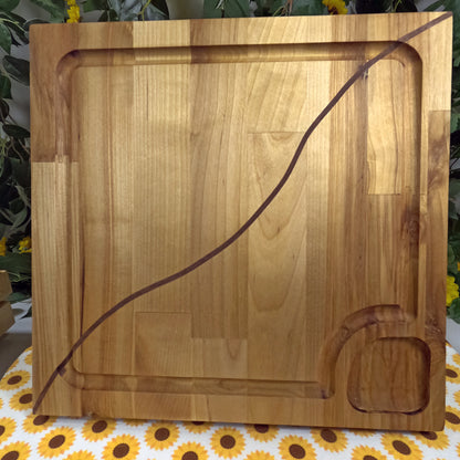 Wooden cutting board with a decorative edge on a floral tablecloth