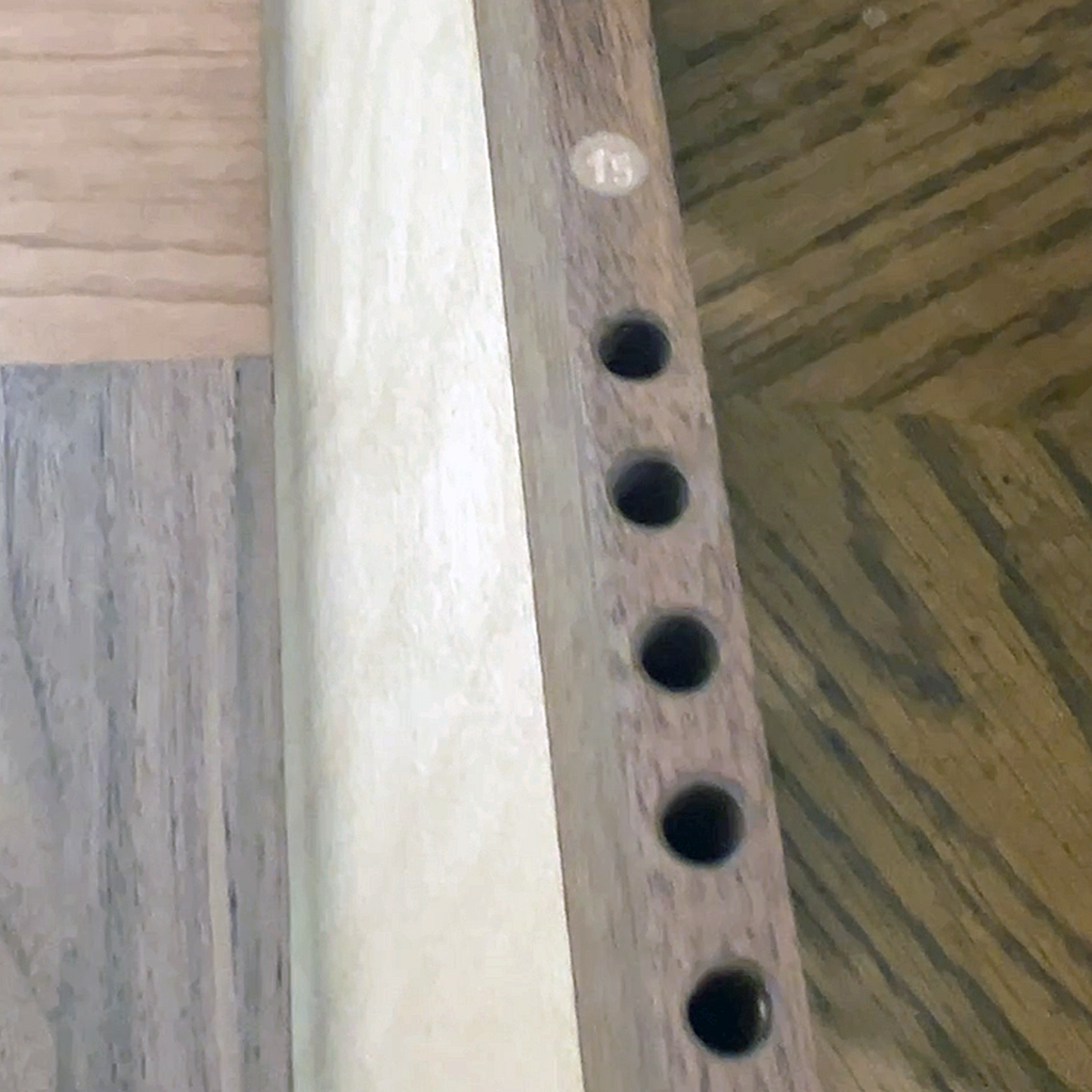 Wooden rail with holes on a wooden background