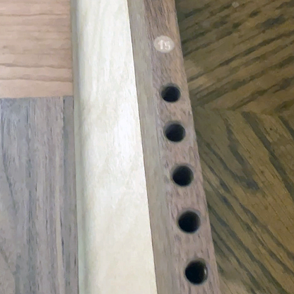 Wooden rail with holes on a wooden background