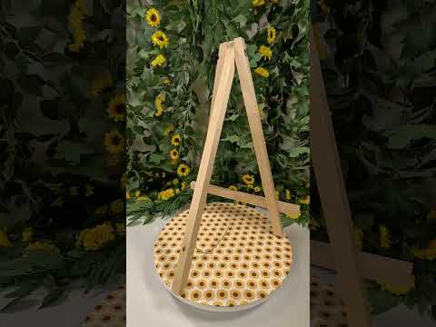 Picture of a video showing an easel on a sunflower table clothe with a vine and sunflower backdrop.