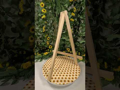 Picture of a video showing an easel on a sunflower table clothe with a vine and sunflower backdrop.